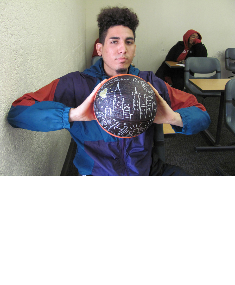 Participant in David Huffman's project Pyramid 3, showing his drawing on a basketball